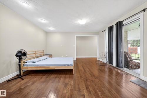 Spacious room featuring rich wood-finish flooring, recessed ceiling lighting, and crown molding - 34 Grand Meadow Crescent, Edmonton, AB 