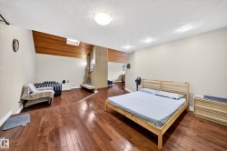Interior space featuring wood-finish flooring, a brick fireplace with a hearth, and a vaulted wood-paneled ceiling with an integrated skylight - 