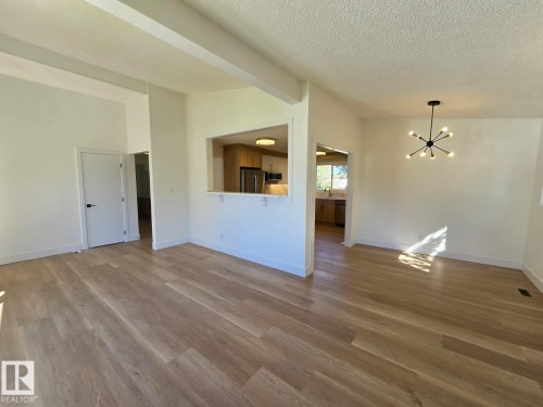 Open concept living space featuring wood-finish flooring and a contemporary chandelier - 18526 86A Avenue, Edmonton, AB - Indoor