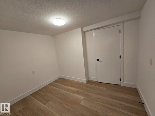 Neutral white walls with wood-finish flooring - 18526 86A Avenue, Edmonton, AB - Indoor Photo Showing Other Room