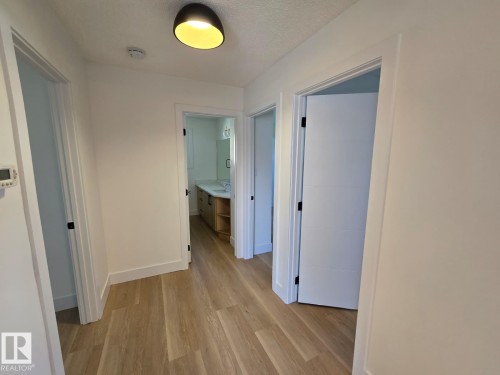 Hallway featuring wood-finish flooring, white trim, and a contemporary ceiling light fixture - 18526 86A Avenue, Edmonton, AB - Indoor Photo Showing Other Room