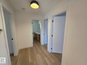 Hallway featuring wood-finish flooring, white trim, and a contemporary ceiling light fixture - 18526 86A Avenue, Edmonton, AB  - Indoor Photo Showing Other Room 