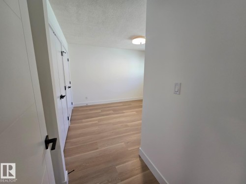 Light wood-finish flooring with white baseboards throughout - 18526 86A Avenue, Edmonton, AB - Indoor Photo Showing Other Room
