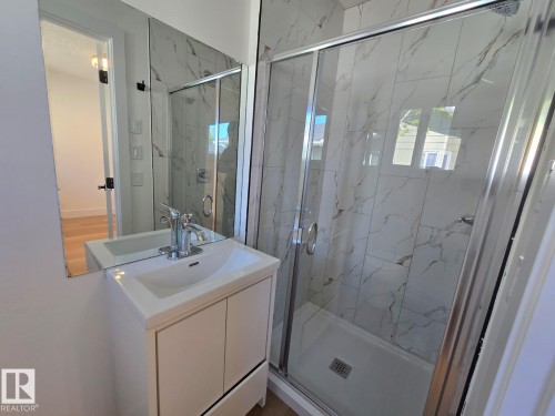 Bathroom featuring a white vanity with integrated sink, chrome faucet, and a large wall-mounted mirror - 18526 86A Avenue, Edmonton, AB - Indoor Photo Showing Bathroom
