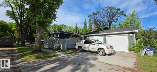 Attached two-car garage with white garage doors and a paved driveway - 6704 93 Street, Edmonton, AB 