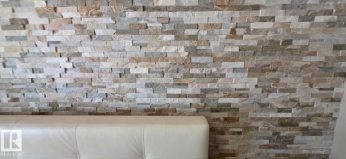 Accent wall featuring natural stone cladding in varying earth tones - 6704 93 Street, Edmonton, AB 