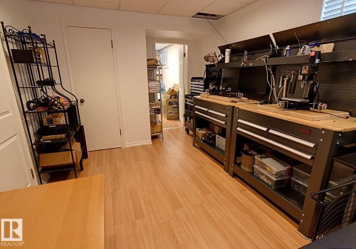 Versatile room featuring wood-finish flooring and white walls - 6704 93 Street, Edmonton, AB 