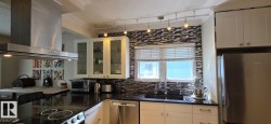 Modern kitchen with black countertops and a mosaic tile backsplash - 