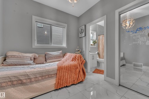 Bright room featuring white tile flooring, a window with horizontal blinds, and a mirrored sliding door - 2419 15 Avenue, Edmonton, AB 