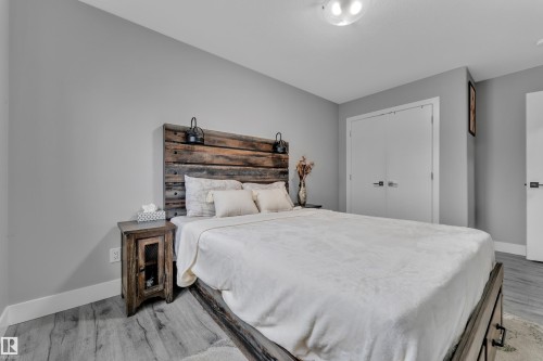 Spacious room featuring light gray walls, wood-finish flooring, and white trim - 2419 15 Avenue, Edmonton, AB 