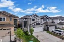 Contemporary gray siding home featuring a white trim garage door, gabled rooflines, and a concrete driveway - 2419 15 Avenue, Edmonton, AB 