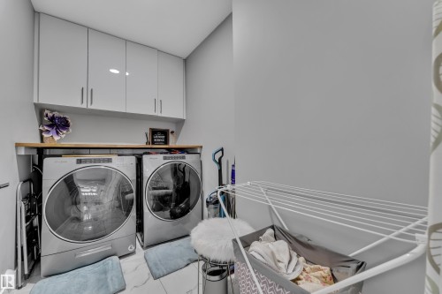 Dedicated laundry area featuring a front-loading washer and dryer set - 2419 15 Avenue, Edmonton, AB 