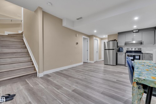 Open-concept living space featuring wood-finish flooring, recessed lighting, and a neutral color palette - 2419 15 Avenue, Edmonton, AB 