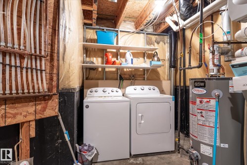 Dedicated utility area featuring a washer and dryer, water heater, and exposed overhead plumbing - 37 4020 21 Street, Edmonton, AB 