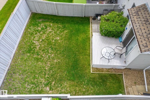 Private backyard featuring a wooden privacy fence, a spacious deck, and a patio area - 37 4020 21 Street, Edmonton, AB 