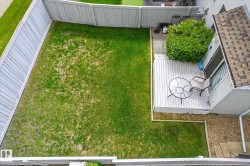 Private backyard featuring a wooden privacy fence, a spacious deck, and a patio area - 