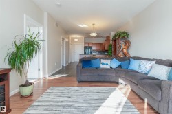 Open-concept living area featuring wood-finish flooring and light neutral wall colors - 