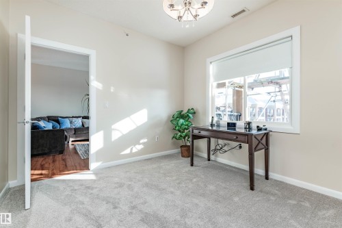 Carpeted room with a large window featuring a roller shade and white trim - 439 300 Palisades Way, Sherwood Park, AB - Indoor Photo Showing Other Room