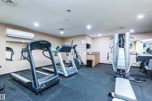 Fitness area featuring rubber flooring, recessed lighting, wall-mounted mirrors, and an air conditioning unit - 439 300 Palisades Way, Sherwood Park, AB - Indoor Photo Showing Gym Room