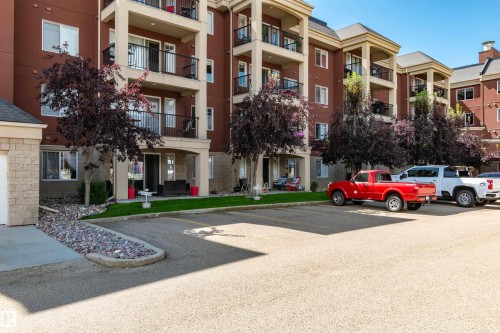Multi-story residential building with red exterior siding and light-colored trim - 439 300 Palisades Way, Sherwood Park, AB - Outdoor With Balcony With Facade