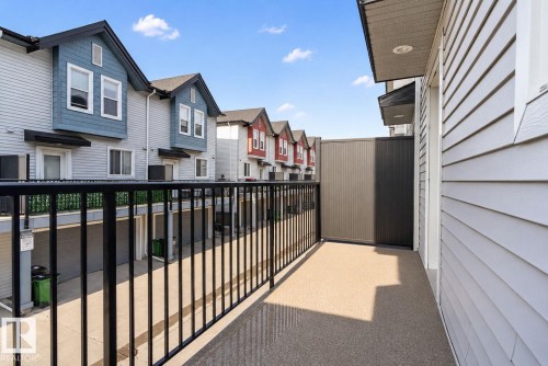 Private balcony featuring an exterior wall with horizontal siding and a black metal railing - 30 6075 Schonsee Way, Edmonton, AB 