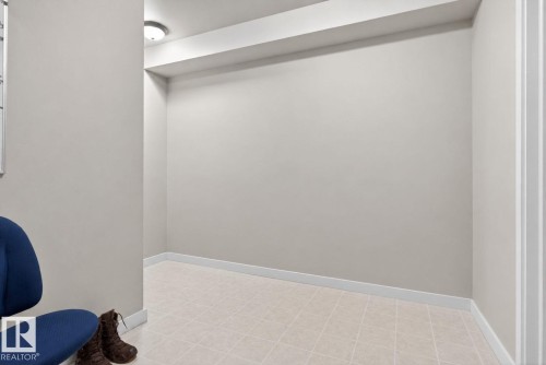 Recessed alcove with neutral wall paint, tile flooring, and crisp white baseboards, illuminated by a ceiling-mounted light fixture - 30 6075 Schonsee Way, Edmonton, AB 