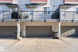 Exterior featuring multiple attached garages with gray panel doors and a concrete driveway - 