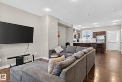 Open-concept living area featuring wood-finish flooring, recessed lighting, and light-toned wall paint - 