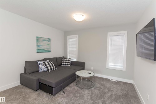 Carpeted living area featuring light gray walls, white trim, and two windows with white blinds - 15168 16 Street Nw, Edmonton, AB 