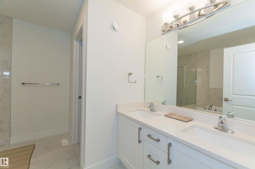 Dual vanity with white cabinetry, polished chrome hardware, and undermount sinks - 15168 16 Street Nw, Edmonton, AB 