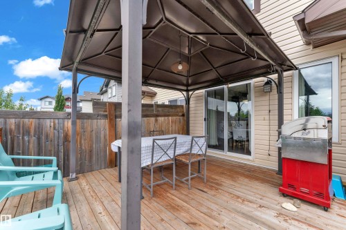 Expansive wood-finish deck featuring a gazebo, privacy fencing, and direct access to interior spaces via sliding glass doors - 1532 33B Street, Edmonton, AB 
