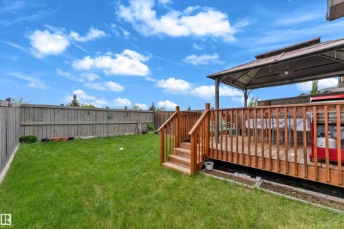 Expansive backyard featuring a natural wood fence and a multi-level wood-finish deck with a built-in gazebo - 1532 33B Street, Edmonton, AB 