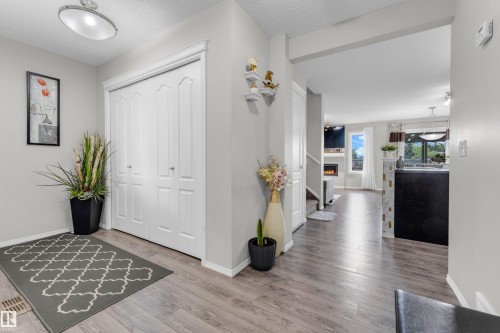 Entryway featuring wood-finish flooring, a bi-fold closet, and recessed lighting - 1532 33B Street, Edmonton, AB 