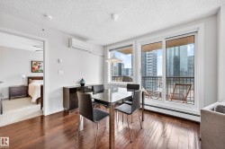 Dining area featuring wood-finish flooring, a wall-mounted air conditioning unit, and a built-in credenza - 