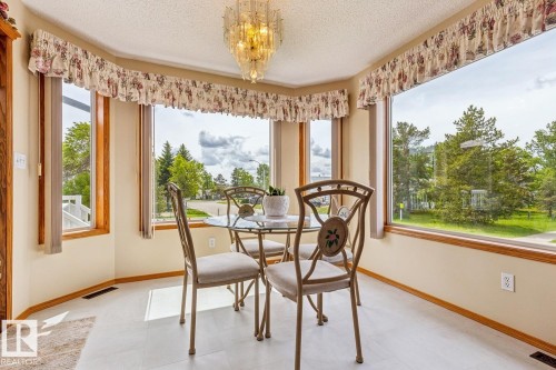 Bay window area featuring light-toned walls, wood-finish trim, a textured ceiling - 5131 152A Avenue, Edmonton, AB 