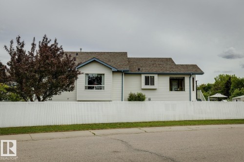White vinyl siding exterior with a brown shingle roof and blue trim - 5131 152A Avenue, Edmonton, AB 