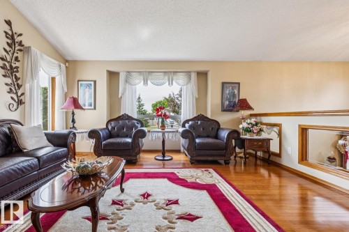 Hardwood flooring throughout the living area, complemented by a recessed window with decorative valance - 5131 152A Avenue, Edmonton, AB 