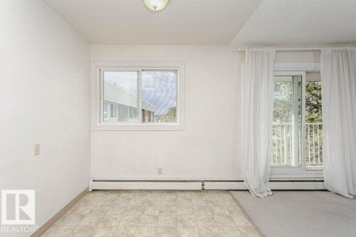 Neutral color palette throughout featuring a sliding glass door with balcony access - 71 11255 31 Avenue, Edmonton, AB - Indoor Photo Showing Other Room