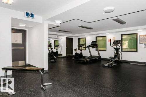 Fitness room with black rubber flooring, recessed lighting, and mirrored wall accents - 71 11255 31 Avenue, Edmonton, AB - Indoor Photo Showing Gym Room