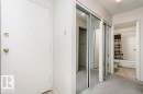 Entryway featuring a white door with brass hardware, mirrored closet doors, and light-toned carpeting - 71 11255 31 Avenue, Edmonton, AB  -  Photo Showing Other Room 
