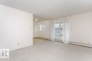 Spacious room featuring light-colored carpeting, white painted walls, and a textured ceiling - 71 11255 31 Avenue, Edmonton, AB  - Indoor Photo Showing Other Room 