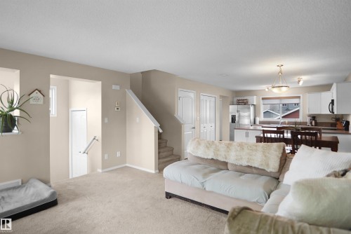 Expansive open-concept living area featuring neutral-toned carpeting and walls - 292 Simmonds Way, Leduc, AB 