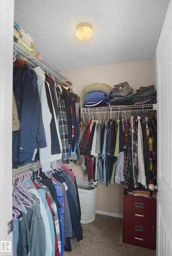 Walk-in closet with carpet flooring, wire shelving, and overhead lighting - 292 Simmonds Way, Leduc, AB 