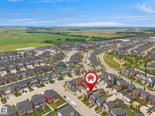 Aerial perspective showcasing a residential neighborhood with varied home styles and expansive green spaces - 292 Simmonds Way, Leduc, AB 