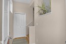 Entryway featuring a white bi-fold door, wood-finish flooring, and a window providing natural illumination - 292 Simmonds Way, Leduc, AB 