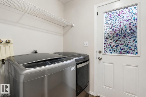 Utility room featuring a white wire shelving unit, painted walls, and a white paneled door with decorative glass - 1804 121 Street, Edmonton, AB 