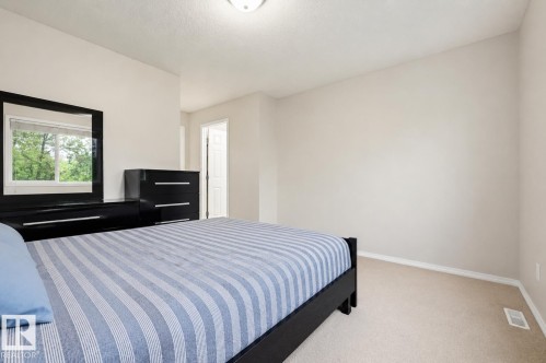 Carpeted bedroom with a window providing natural light - 1804 121 Street, Edmonton, AB 