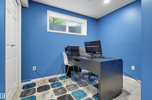 Finished room with bright blue walls, a white trim window, recessed ceiling lighting, and light wood-finish flooring - 1804 121 Street, Edmonton, AB 