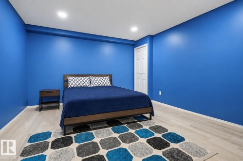 Room featuring light wood-finish flooring, recessed ceiling lighting, and a white six-panel door - 1804 121 Street, Edmonton, AB 