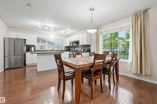 Open-concept kitchen and dining area featuring wood-finish flooring - 1804 121 Street, Edmonton, AB 